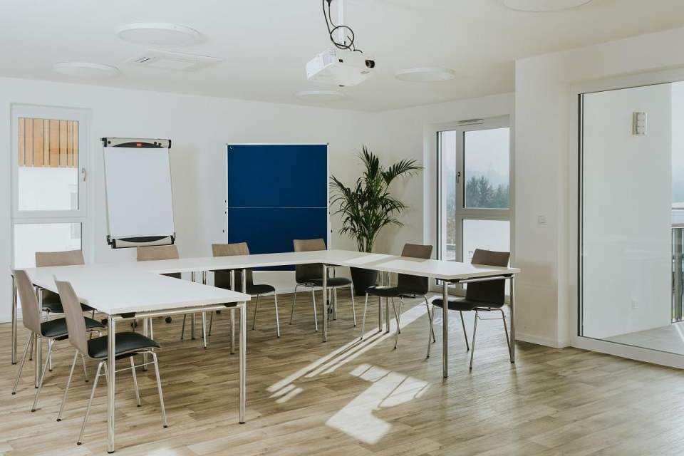 Seminarraum mit Tischen in U-Form, Flipchart, Pinnwand und Beamer